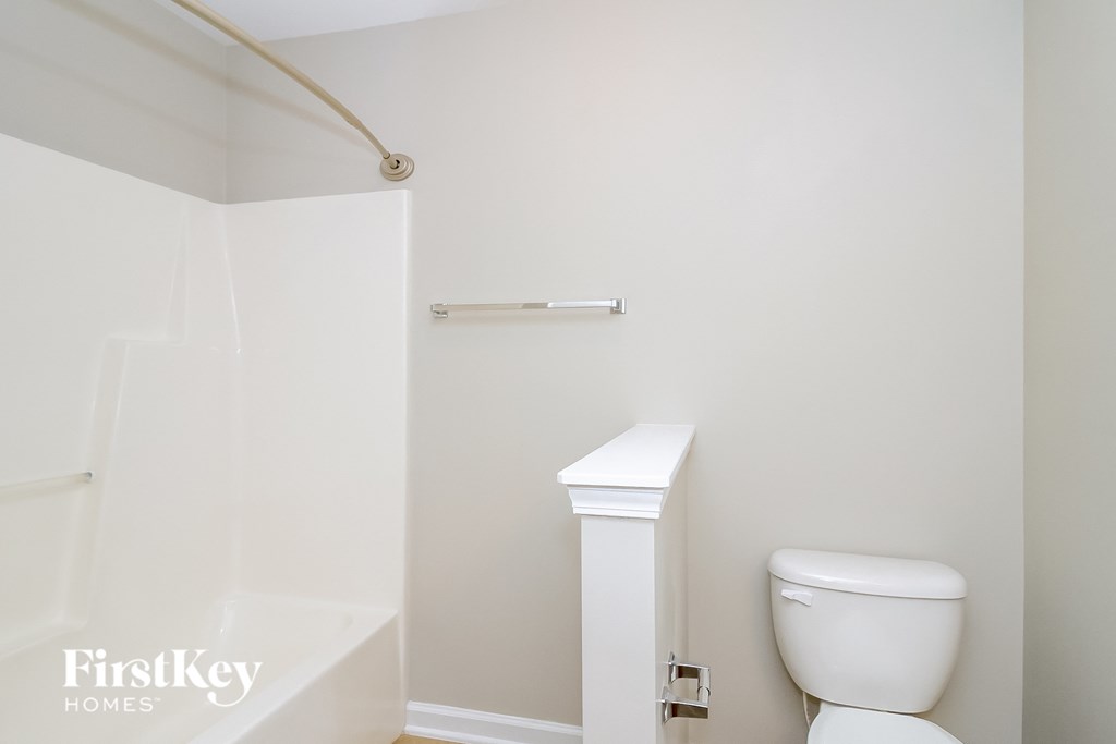 a bathroom with a toilet and a tub and a shower curtain