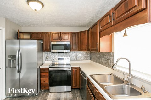 a kitchen with wooden cabinets and stainless steel appliances