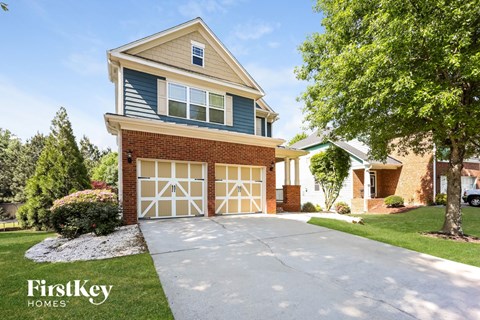 A house with a garage and a driveway in front of it.