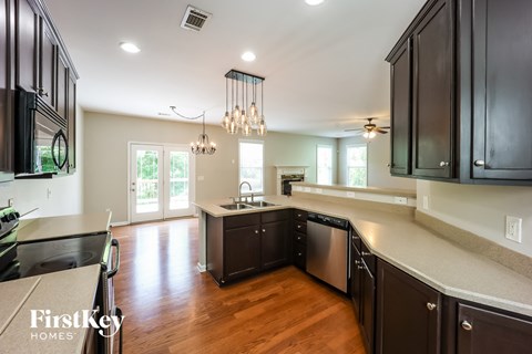 A kitchen with dark wood cabinets and a stainless steel dishwasher.