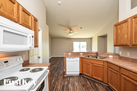 A kitchen with a white stove top oven and a white microwave.