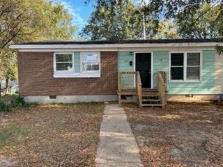 a small house with a brick exterior and a wooden porch