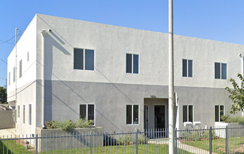 a large white building with a fence in front of it