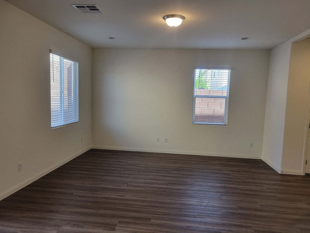 an empty living room with wood floors and a window