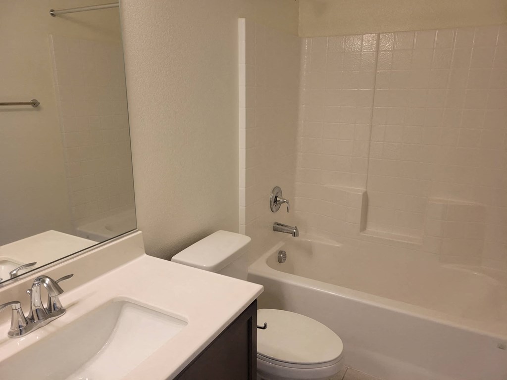 a bathroom with a toilet and a tub and a sink