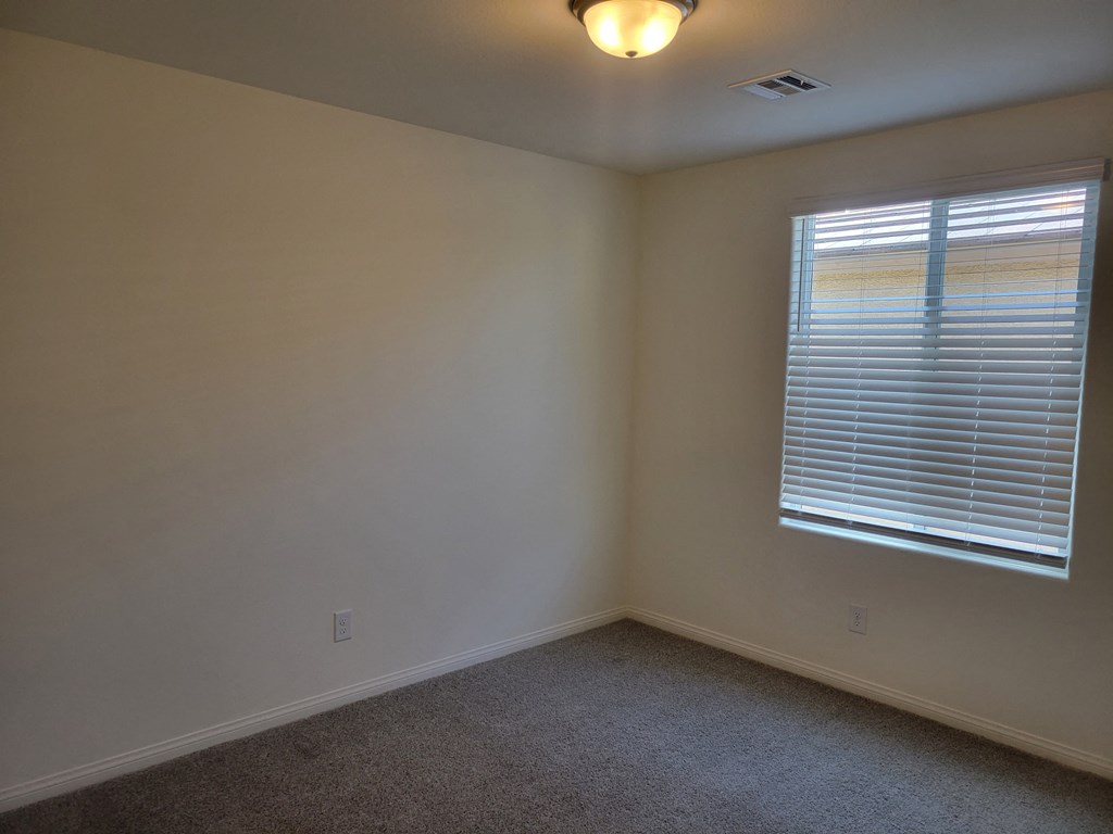 the corner of a room with a window and white walls