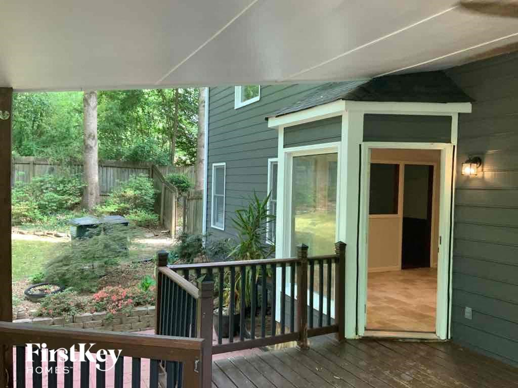 a front porch with a door open to a backyard