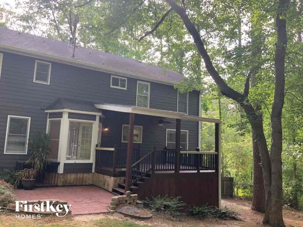 a blue house with a porch and trees