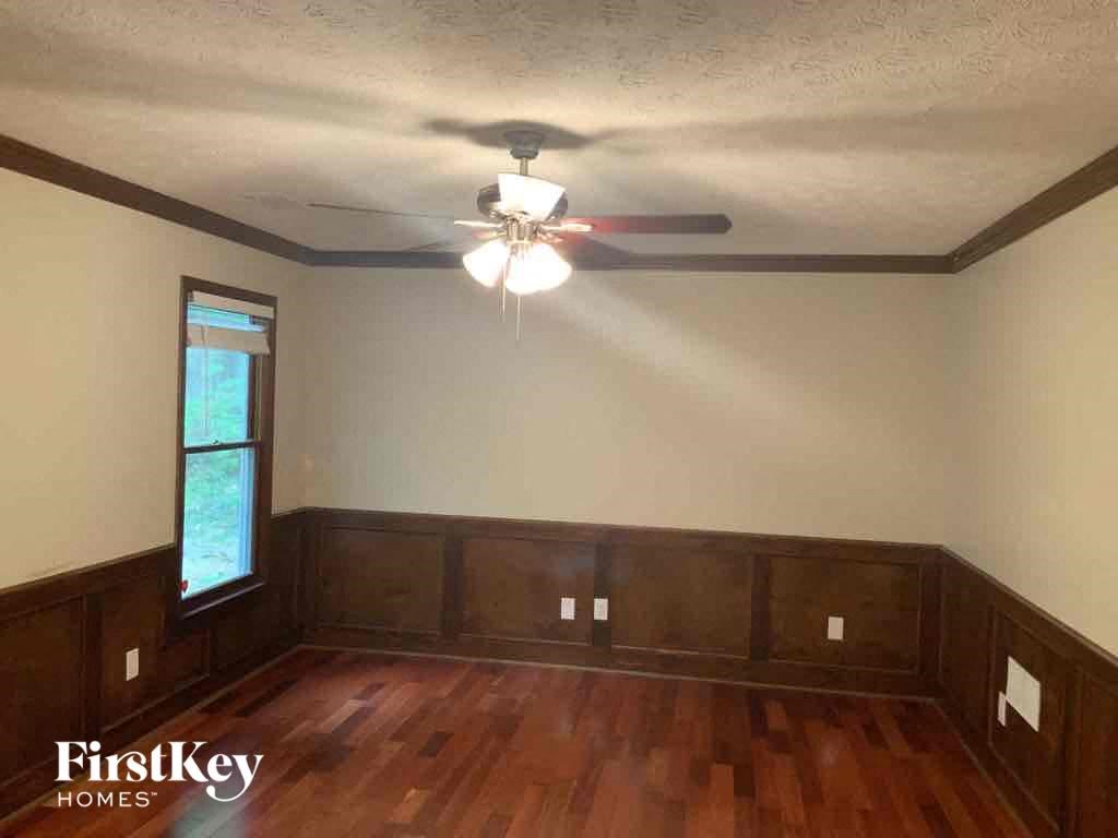 an empty living room with wooden floors and a ceiling fan