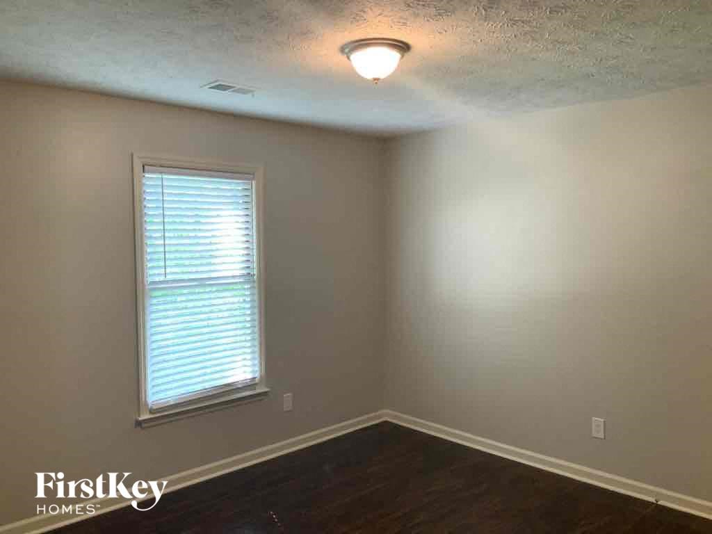 an empty room with a window and a lamp on the ceiling