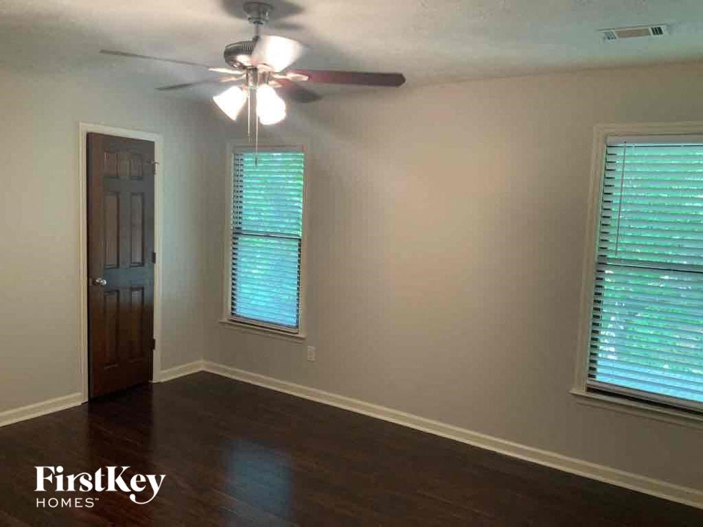 an empty room with a ceiling fan and a window