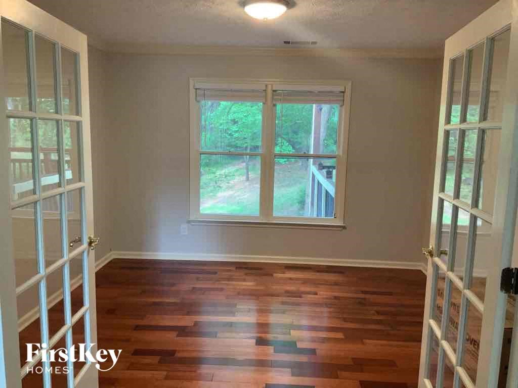 an empty living room with wood floors and a window