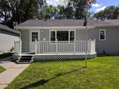 A house with a grey roof and a white porch.