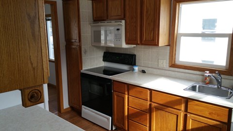 a kitchen with wooden cabinets and a black stove