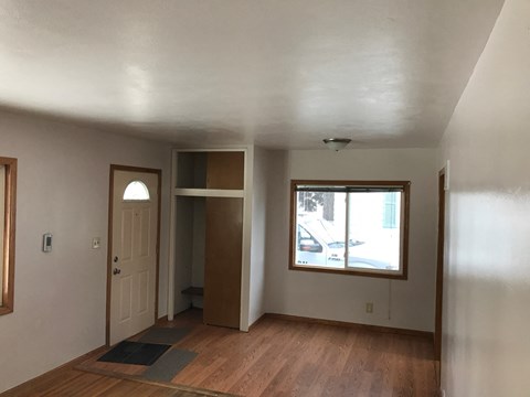 an empty living room with a window and a door