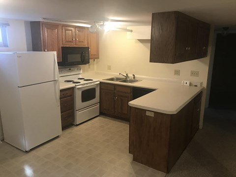A kitchen with a white refrigerator, white stove, and white countertop.
