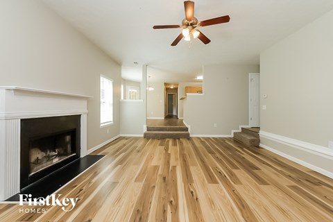 a living room with a fireplace and a ceiling fan