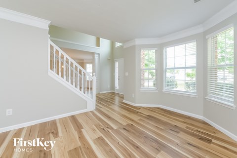 an empty living room with a hard wood floor and a staircase