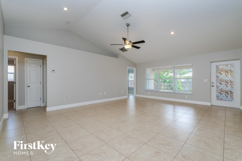 A spacious room with a ceiling fan and tiled flooring.
