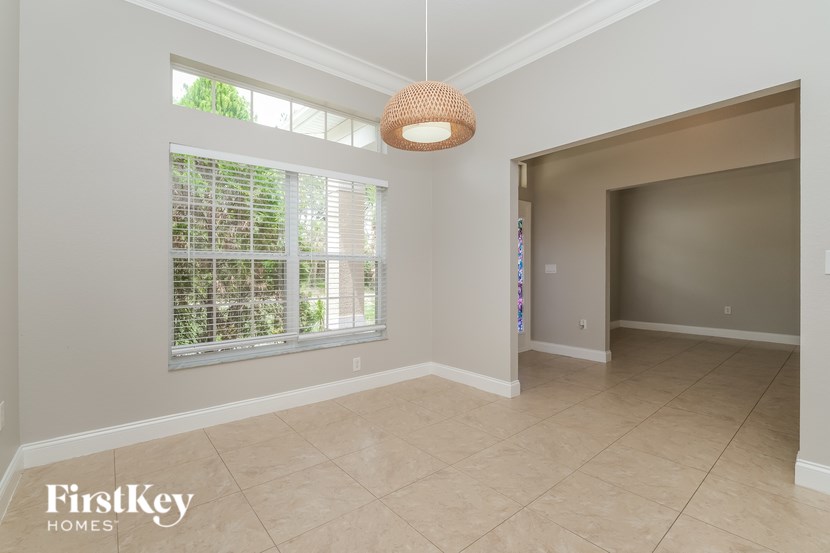 A room with a window and a hanging light fixture.