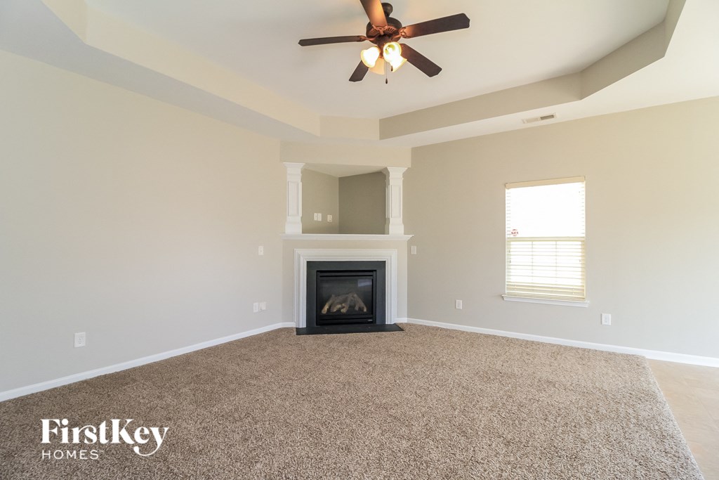 the living room with fireplace and ceiling fan