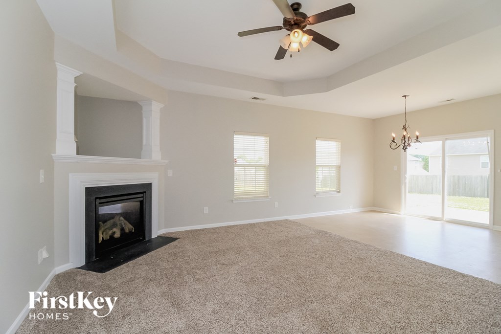 the living room with fireplace and ceiling fan