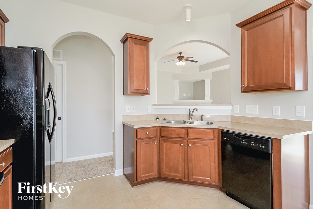 a kitchen with wooden cabinets and a sink and a refrigerator