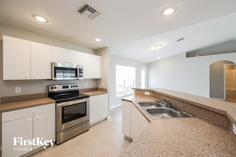 A kitchen with a stove top oven and a microwave above it.