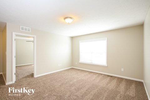 the upstairs bedroom has carpet and a large window