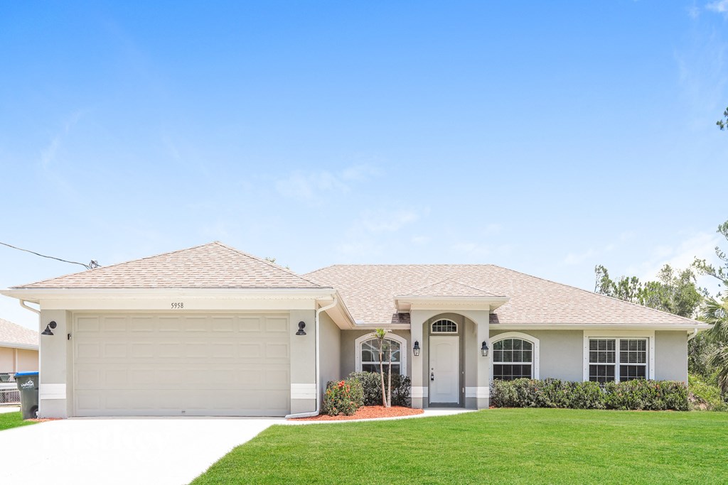 a beige house with a lawn in front of it