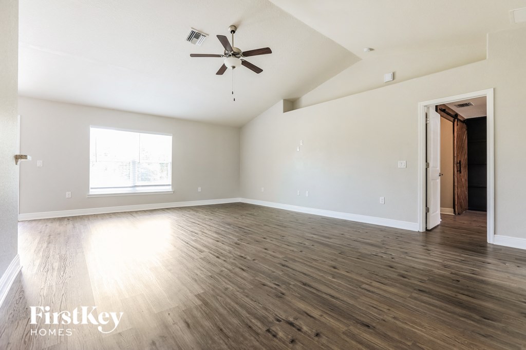 an empty living room with white walls and wood floors