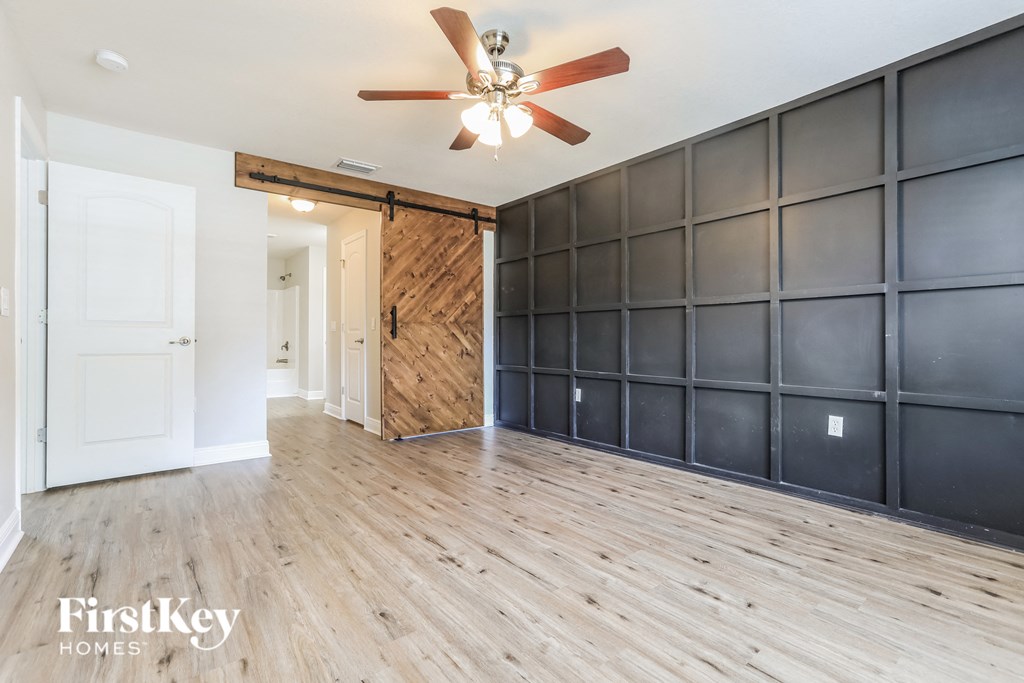 a living room with a wood floor and a wall with a sliding barn door