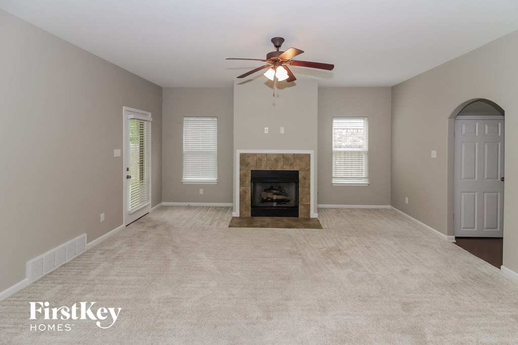 a living room with a fireplace and a ceiling fan