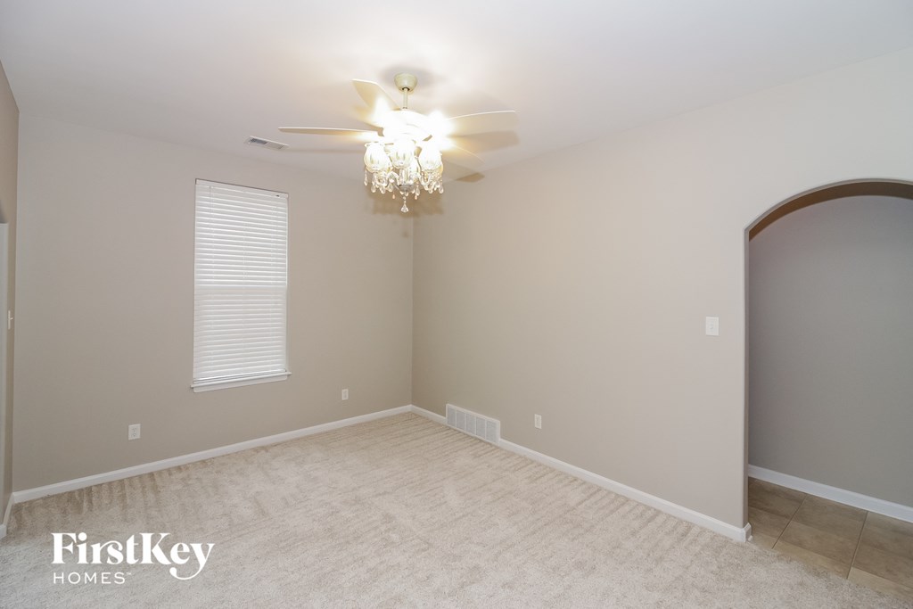 a bedroom with a ceiling fan and a arched door