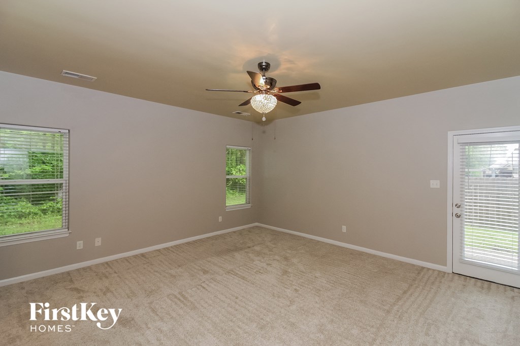 an empty bedroom with a ceiling fan and a window