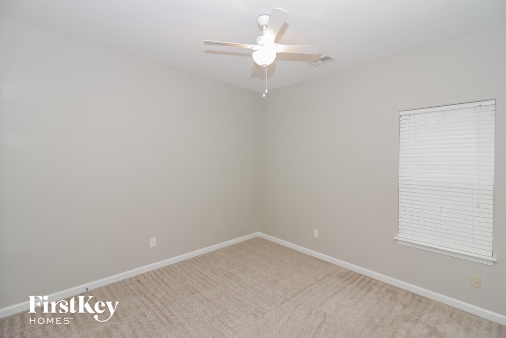 a bedroom with a ceiling fan and a window