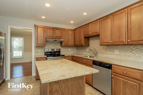 a kitchen with wooden cabinets and a marble counter top
