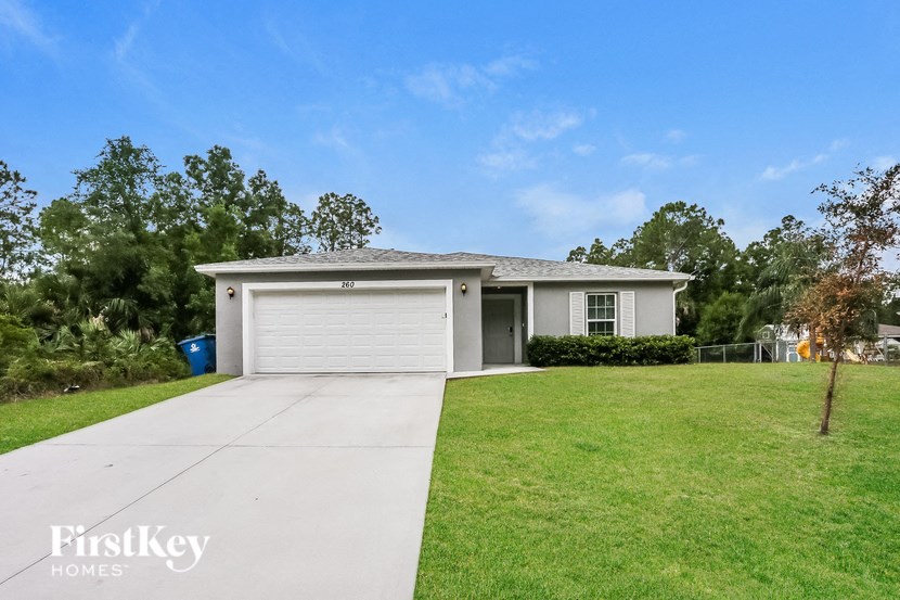 A house with a garage and a driveway in front of it.
