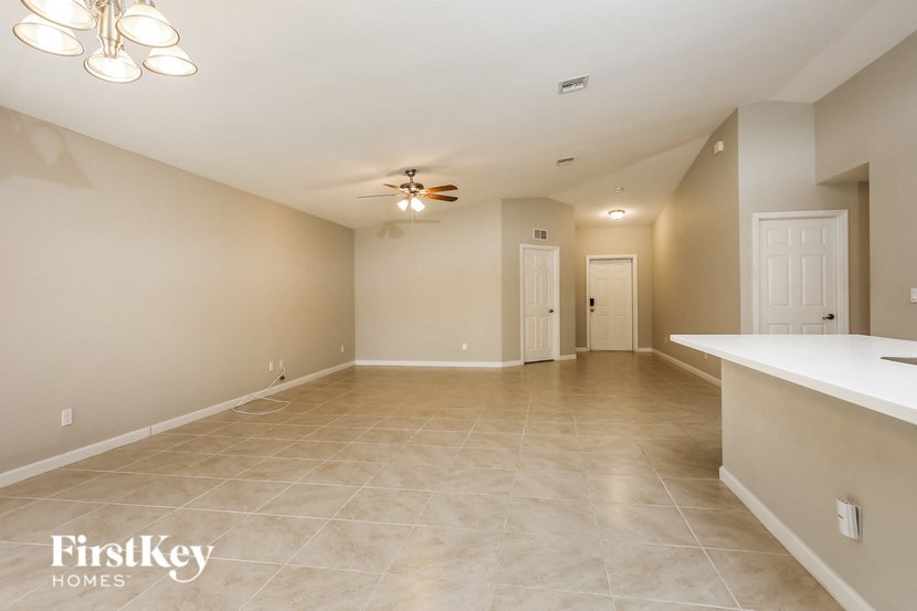 A spacious room with a fan and a bar area.