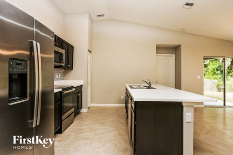 A kitchen with a stainless steel refrigerator and microwave.
