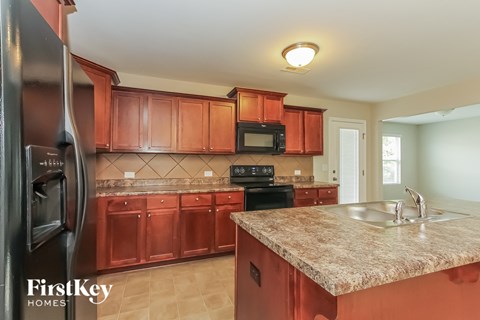 A kitchen with brown cabinets and a granite countertop.