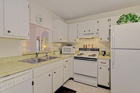 a kitchen with white appliances and white cabinets
