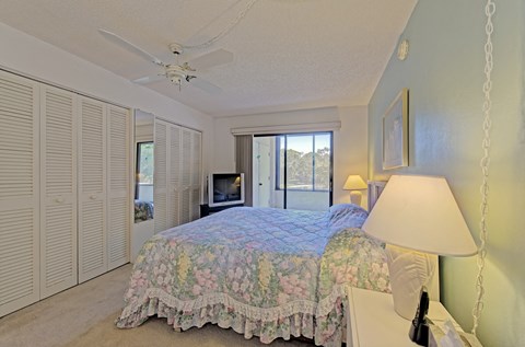 a bedroom with a large bed and a ceiling fan