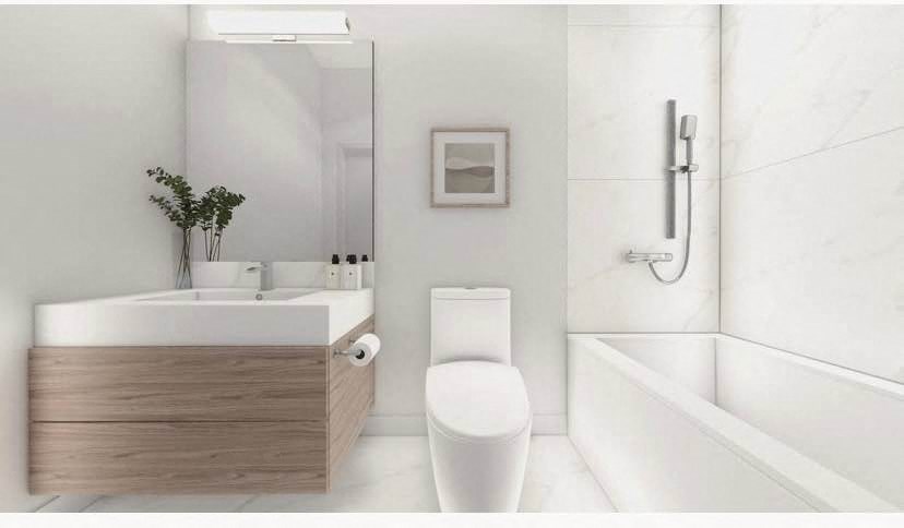 A white toilet sits next to a bathtub in a bathroom.