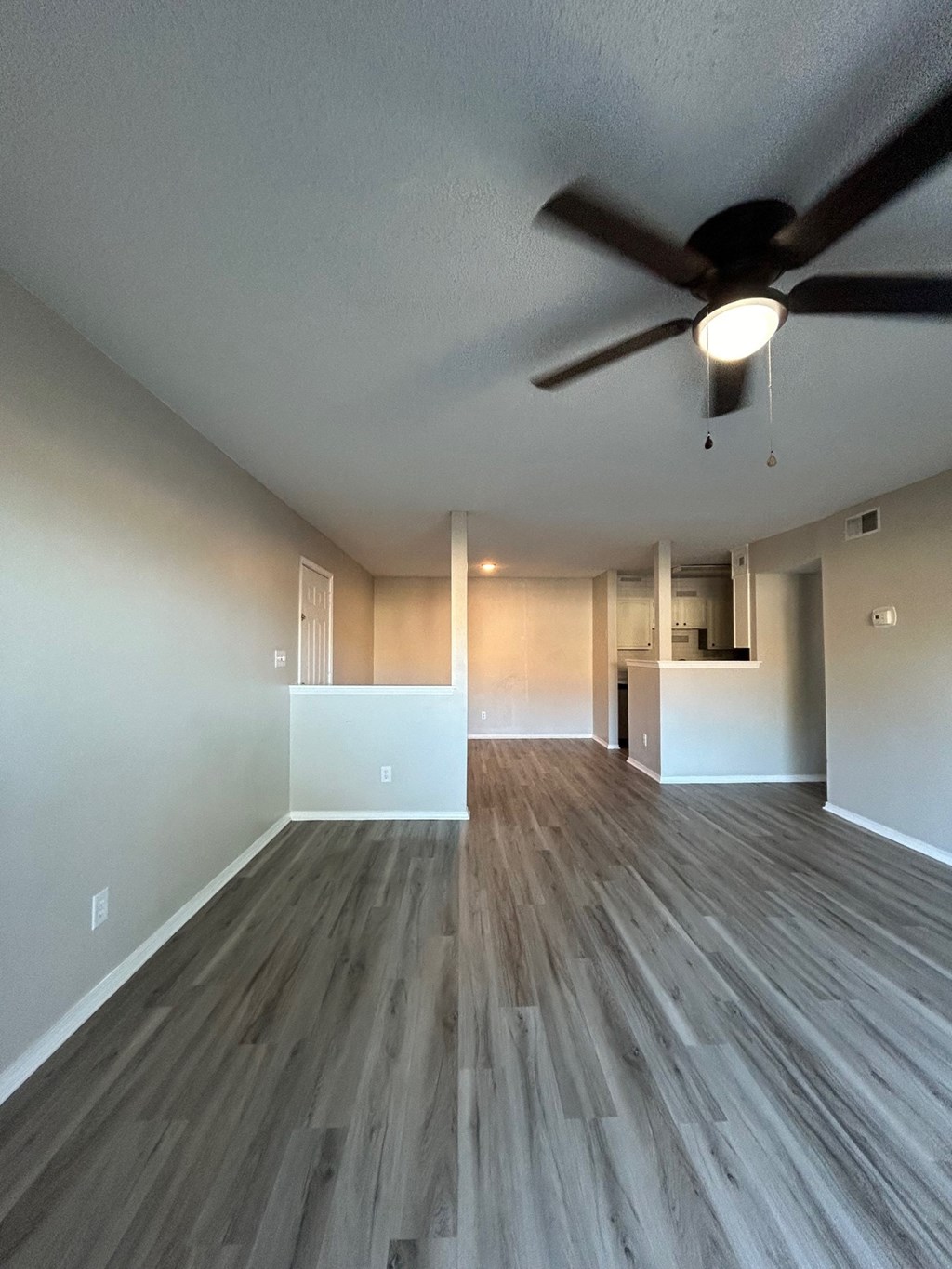 A room with a ceiling fan and light fixture.
