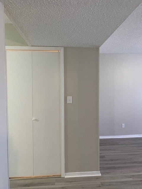 A white closet with a door and a white wall.