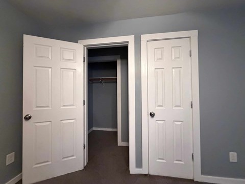 A room with two white doors, one open to a hallway.