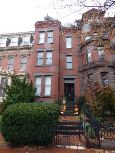 A red brick building with a black gate in front.