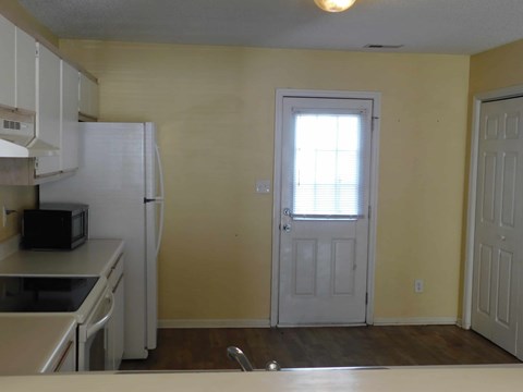 a kitchen with a white refrigerator and a door