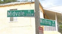 two street signs on a pole in front of a building